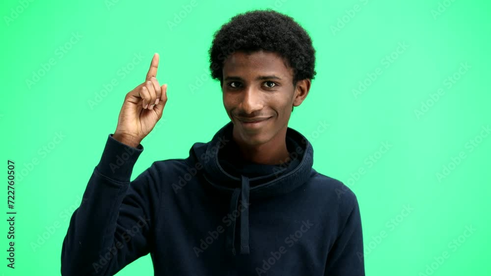Man, close-up, on a green background, pointing up