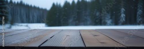 Empty rustic wooden table top on blur background of winter nordic forest. Cloudy moody sky. Abstract snowy counter. Mockup for Eco tourism, hiking ad. Free space for text. Frame for display. Snow dust