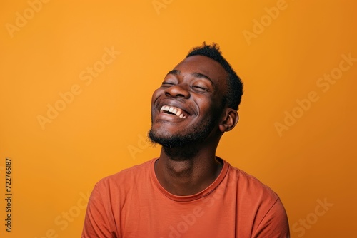 Man in a fit of laughter  orange studio setting