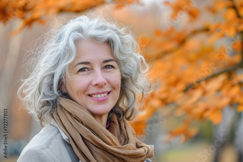 Smiling gray-haired woman outdoors in autumn, lovely portrait