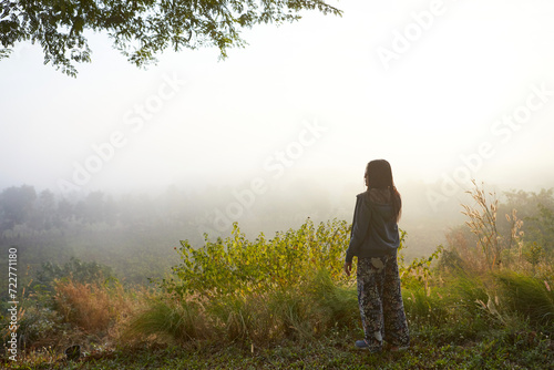 Rear view of woman standing in forest during misty morning © Cavan