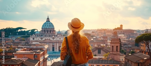 Young traveler woman exploring city famous landmarks. Back view of female tourist enjoying historic on sunny vacation day in urban. Caucasian woman touring culture and religion in beautiful cityscape photo
