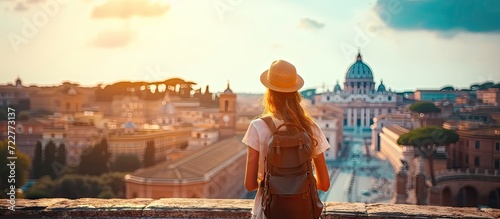 Young traveler woman exploring city famous landmarks. Back view of female tourist enjoying historic on sunny vacation day in urban. Caucasian woman touring culture and religion in beautiful cityscape © Wuttichai