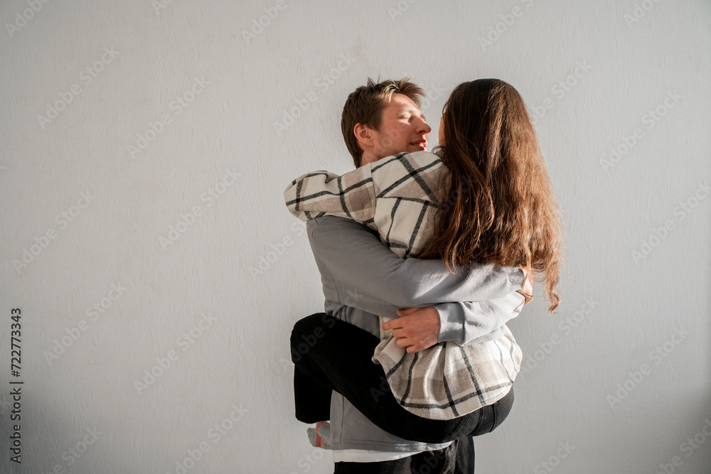 A man showcases his strength and love by carrying his partner on his back, supporting her with his hands intertwined with hers. A man showcases his strength and love by carrying his partner on his back, supporting her with his hands intertwined with hers.