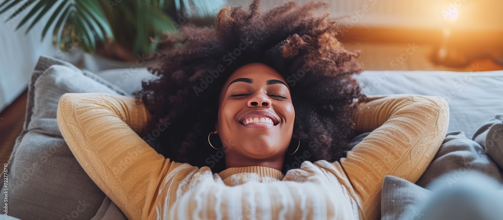 Portrait happy afro african american woman relaxing on the sofa at ...