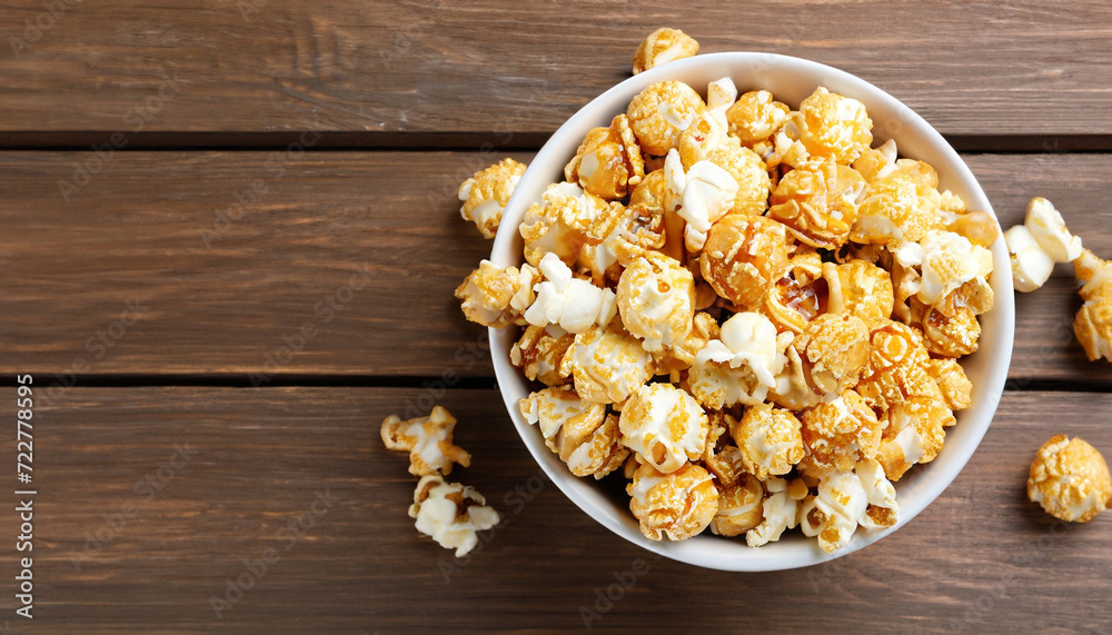 popcorn with caramel in bowl on wooden background, top view popcorn with caramel in bowl on wooden background, top view