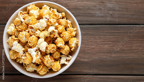 popcorn with caramel in bowl on wooden background, top view