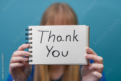 Kobieta wyraża wdzięczność trzymając kartkę z napisanym angielskim słowem dziękuję 