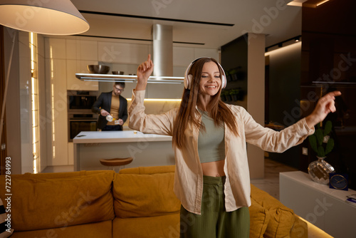 Happy relaxed young woman listening music at home