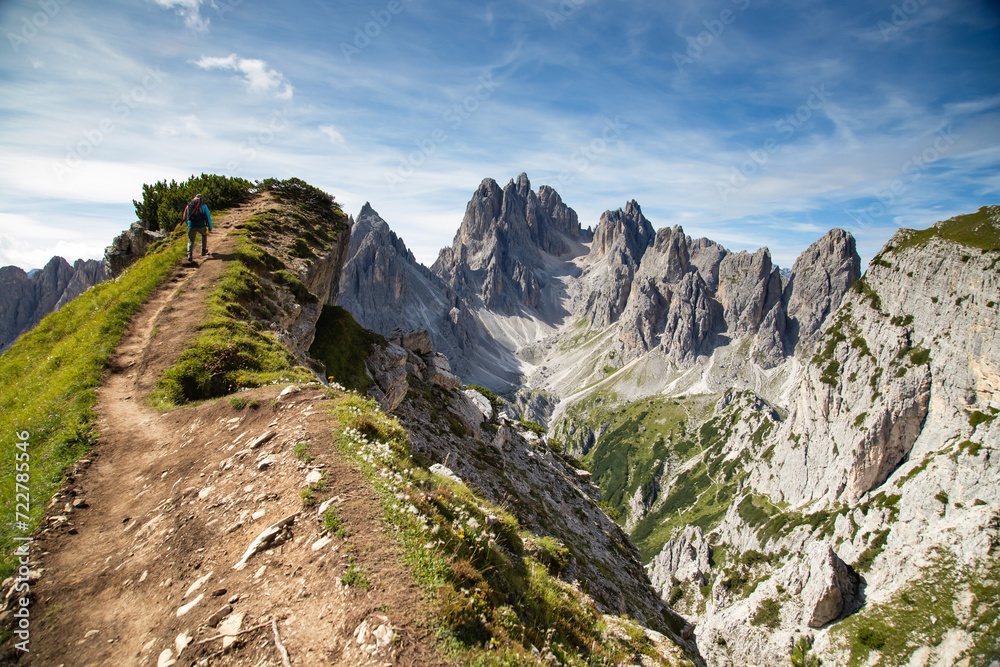 Fototapeta premium Stunning view of a tourist on the top of a hill enjoying the view of the Cadini di Misurina
