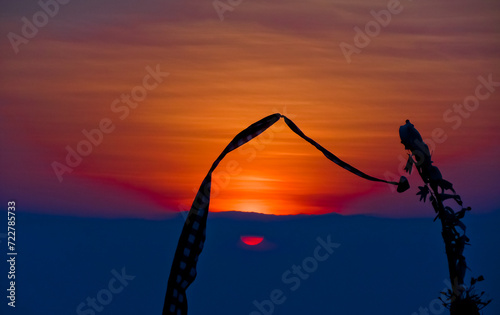 views of Penjor, Janur and Balinese temples with the sunset of Uluwatu, Bali photo