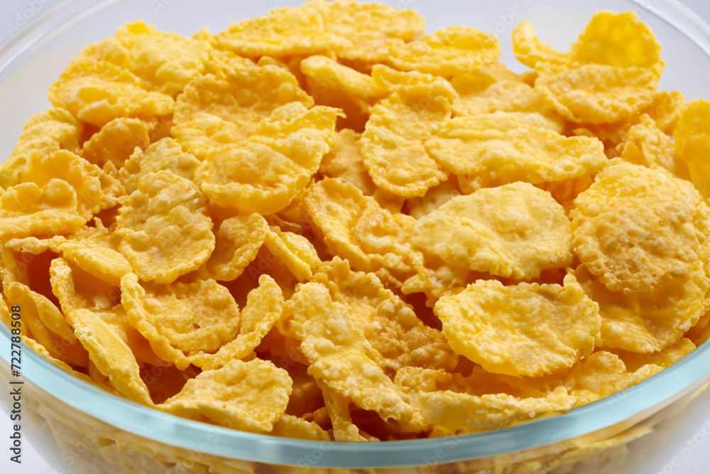 healthy breakfast. there is a transparent plate with yellow cereals close-up on a white table, the concept is sweet healthy breakfast. there is a transparent plate with yellow cereals close-up on a white table, the concept is sweet