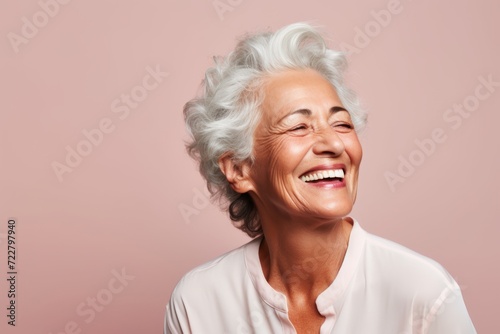 Happy senior woman with white hair. Portrait of a happy senior woman on pink background.