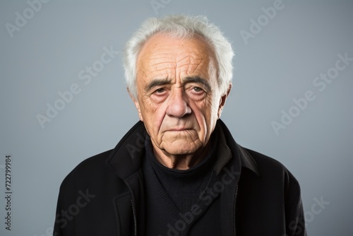 Portrait of an old man with a sad expression over gray background © Loli