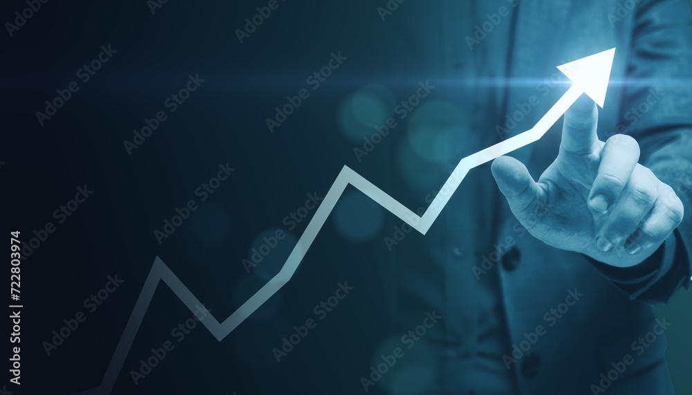 Business executive pointing to an upward arrow, symbolizing leadership and growth Business executive pointing to an upward arrow, symbolizing leadership and growth