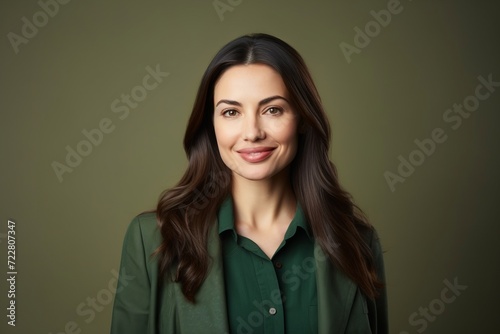 Portrait of happy smiling young business woman, over dark green background