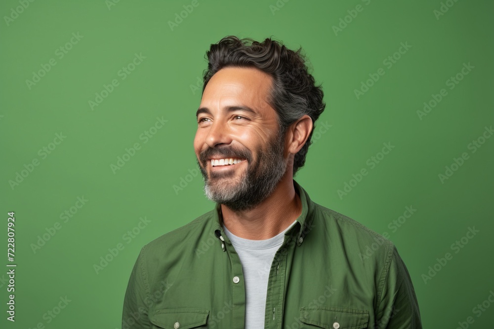Portrait of a handsome man smiling and looking at camera against green background Portrait of a handsome man smiling and looking at camera against green background