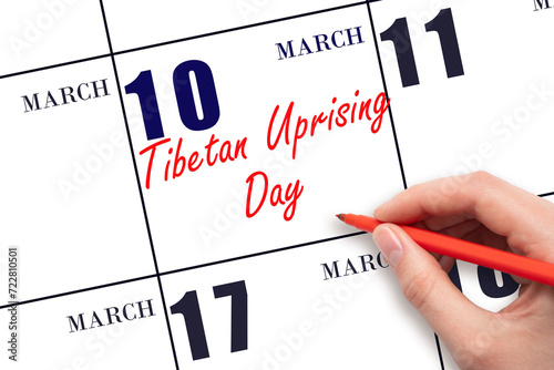 March 10. Hand writing text Tibetan Uprising Day on calendar date. Save the date. photo