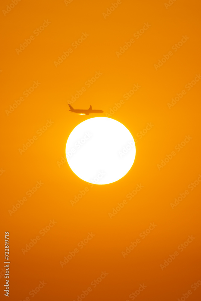 Airplane soaring above radiant sunset