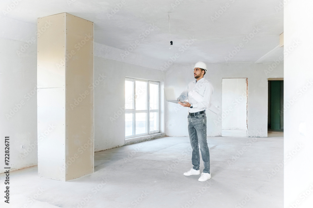 Architect standing with laptop at site Architect standing with laptop at site