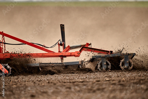 Tractor with plow cultivating field in spring