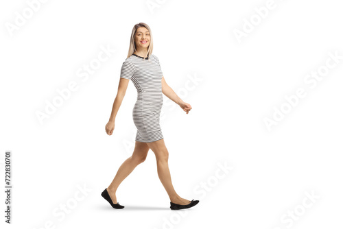 Fototapeta Naklejka Na Ścianę i Meble -  Full length shot of a casual young woman walking and smiling