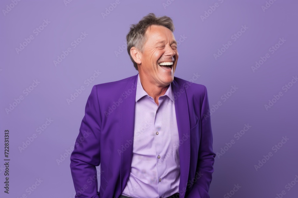 Portrait of a happy senior man laughing while standing against purple background Portrait of a happy senior man laughing while standing against purple background