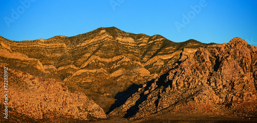 Lever de soleil sur Red Rock Mountain, Las Vegas, Nevada, États-Unis d'Amérique. Montagne à la roche en strates jaunes et or, aride et pelée.