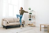 Jumping for Joy: A Carefree Woman Dancing and Singing with Excitement in her Beautiful Home's Living Room