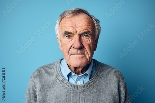Portrait of a senior man with grey hair. Isolated on blue background.