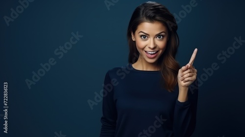 Portrait of funny amazed girl promoter directing fingers empty blank space cool news open mouth isolated dark blue color background photo