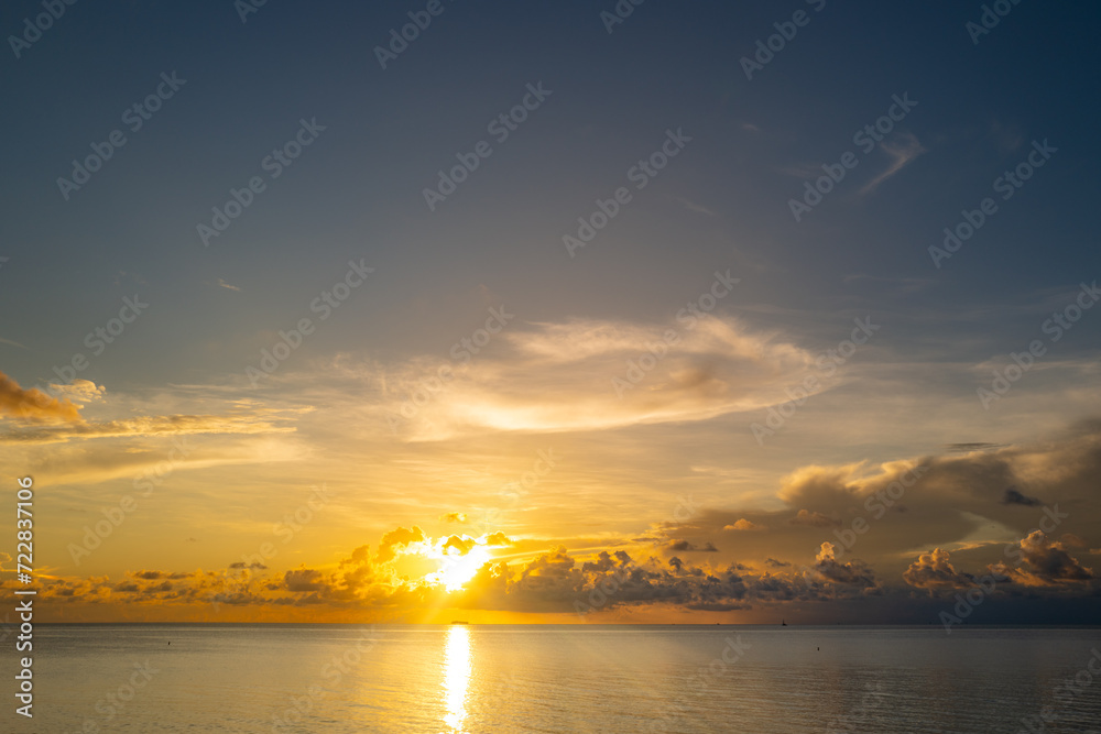 Sunset sea landscape. Colorful beach sunrise with calm waves. Nature sea sky. Sunrise with clouds of different colors against the blue sky and sea. Sunset over Sea with golden dramatic sky panorama.