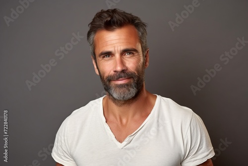 Portrait of handsome mature man with beard and mustache in white t-shirt.