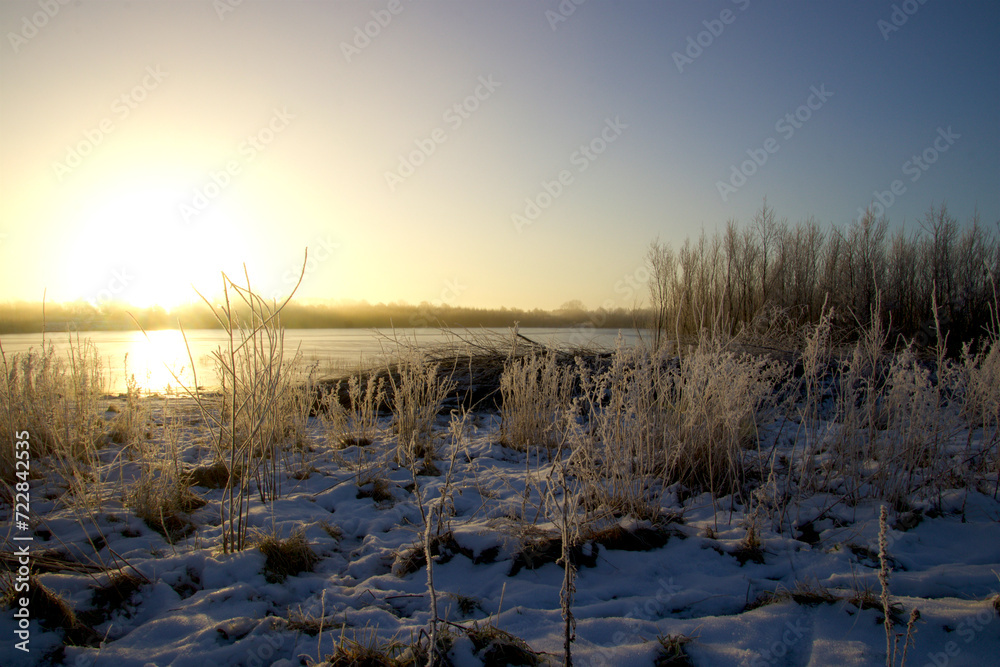 Snow and hoarfrost by the lake at sunrise on a cold winter morning Snow and hoarfrost by the lake at sunrise on a cold winter morning