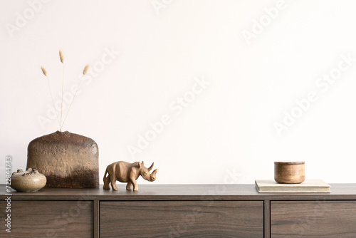 Creative minimalistic composition with white wall and stylish small personal accessories on wooden commode. Copy space. Template.
