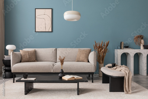 Creative composition of living room interior with mock up poster frame, grey sofa, black coffee table, blue wall, stylish furnitures, decorations and personal accessories. Template. Home decor. 