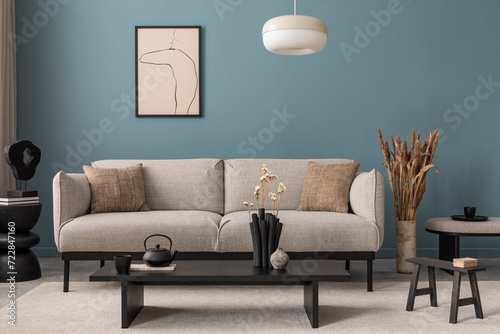 Creative composition of living room interior with mock up poster frame, grey sofa, black coffee table, blue wall, stylish furnitures, decorations and personal accessories. Template. Home decor.  photo
