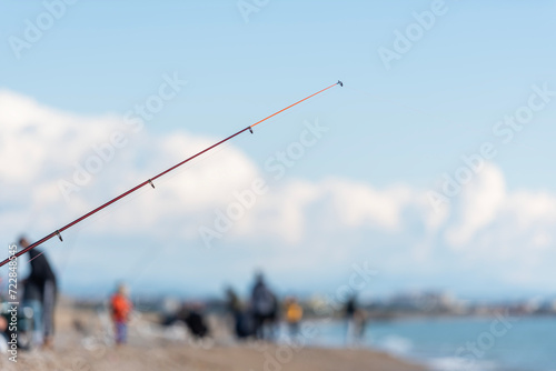 Silhouette image of people fishing on the beach. A large group of people are fishing in the area on the concrete on the breakwater.