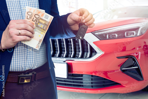 Man holding euro banknote for buy or rent new car at showroom