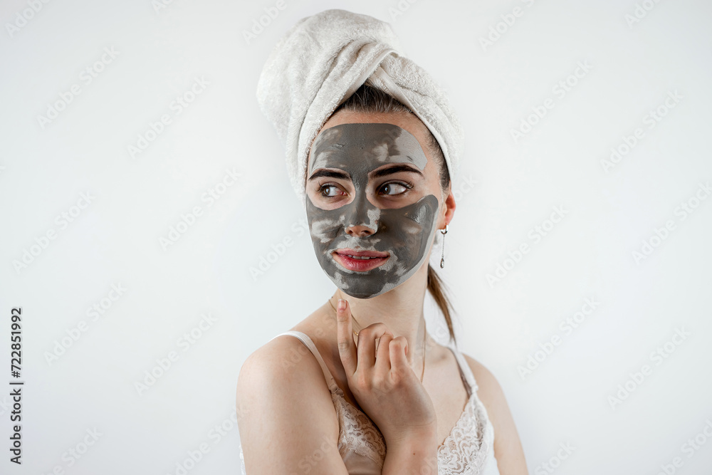 pretty sexy woman applying clay black mask on white background pretty sexy woman applying clay black mask on white background
