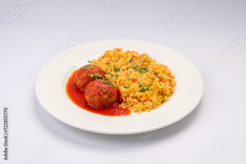 Business lunch. Meat balls in tomato sauce with a side dish of cereals and vegetables on a white background (ID: 722855770)