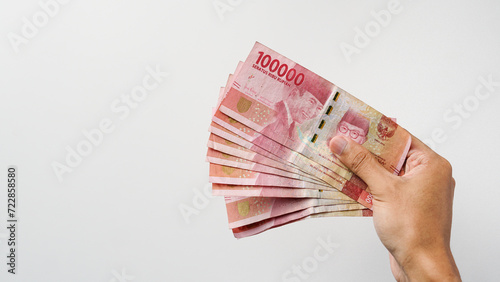 Hand holding Indonesian rupiah money. Indonesian currency