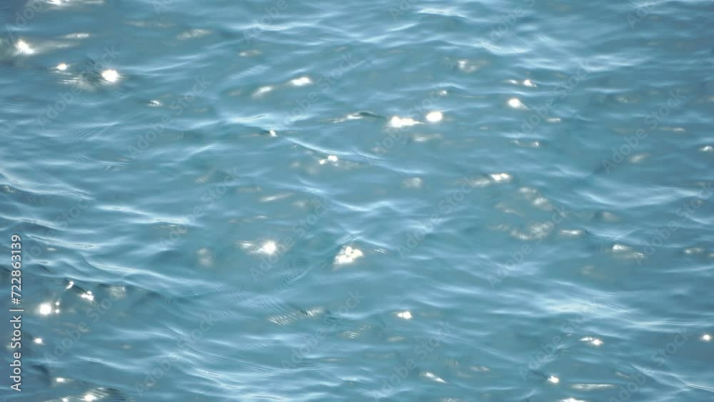 Sea water surface. Aerial view on clear azure sea water. Sun glare. Abstract nautical summer ocean nature. Holiday, vacation and travel concept. Nobody. Slow motion. Weather and climate change