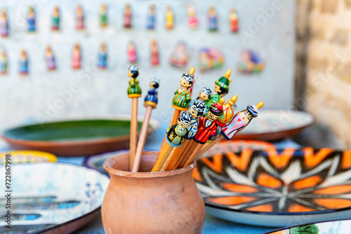 Handmade wooden colorful pencil caps in the form of Uzbek figures. Tourism, souvenir, shopping. Close up, selected focus, copy space. Bukhara, Uzbekistan photo