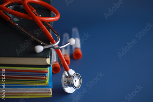 stethoscope on stack of medical guide book for doctor learning treatment at hospital.