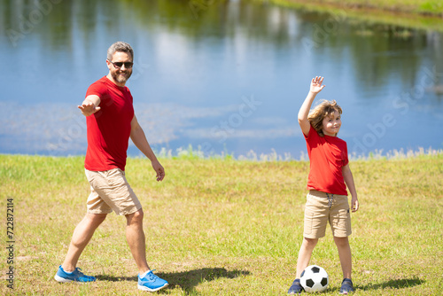 Father and son are part of a sporty family that loves playing football together. They spend weekends on the field practicing their skills and having fun. Father and son stay active as a sporty family.