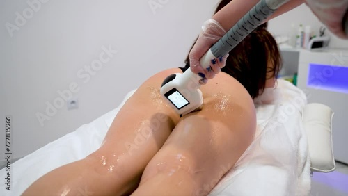 Woman beautician removes hair on beautiful female skin using safe depilation laser at hospital room close up. Laser hair removal procedure in epilation beauty medical spa clinic photo