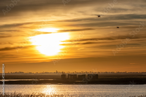 Sonnenuntergang über der Insel Kirr mit der Bauernhofruine. photo