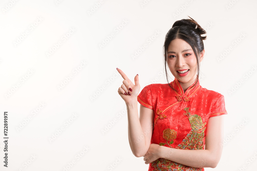 Happy Young Asian woman wearing traditional cheongsam qipao dress hand pointing up to copy space isolated on white background. Happy Chinese new Happy Young Asian woman wearing traditional cheongsam qipao dress hand pointing up to copy space isolated on white background. Happy Chinese new