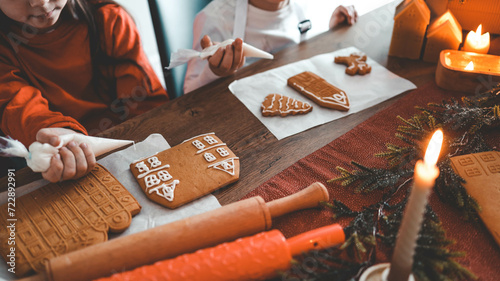 Children decorate gingerbread house, cozy homely Christmas atmosphere